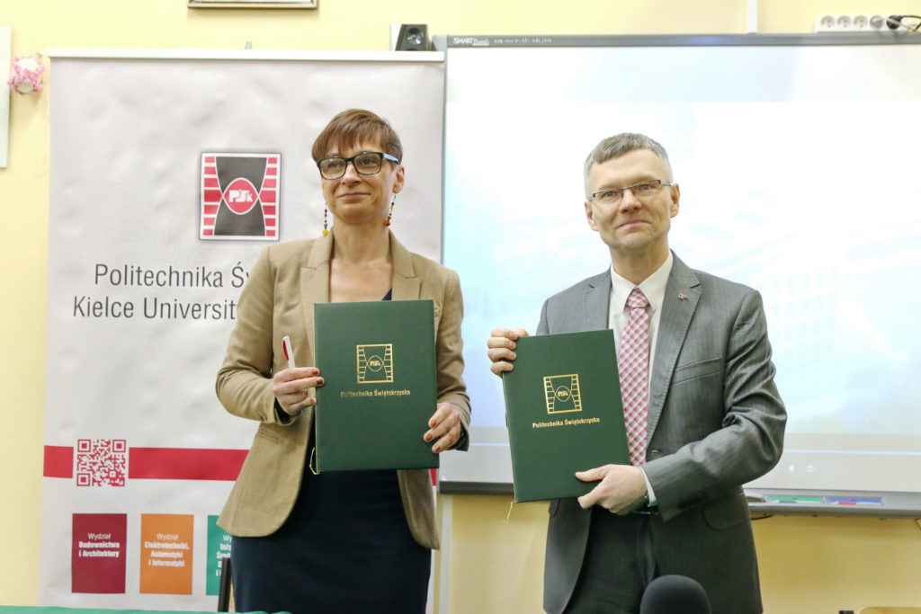 Dwie osoby trzymają zielone teczki z logo Politechniki Świętokrzyskiej. Kontekst: wydarzenie uczelniane.
