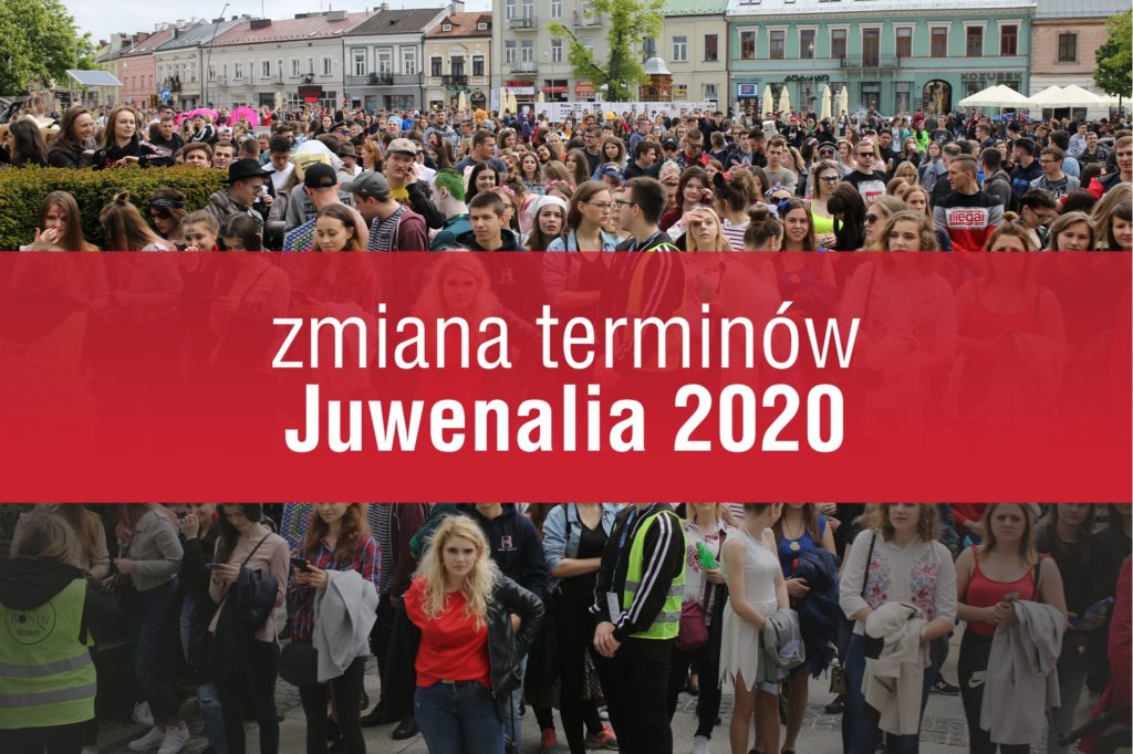 Tłum ludzi na ulicy. Na czerwonym tle napis 