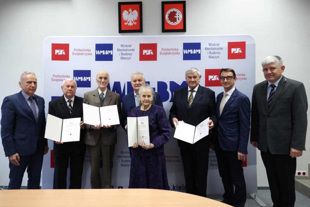 Siedem osób pozuje do zdjęcia z dyplomami. W tle baner Politechniki Świętokrzyskiej.