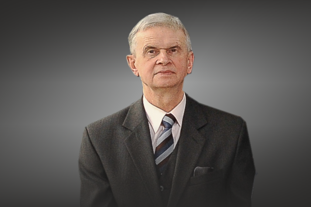 Portret starszego mężczyzny w garniturze i krawacie.