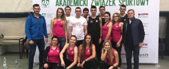 Grupa osób pozuje do zdjęcia przed banerem "Akademicki Związek Sportowy". Kluczowe obiekty: ludzie, baner, logo LOTOS.