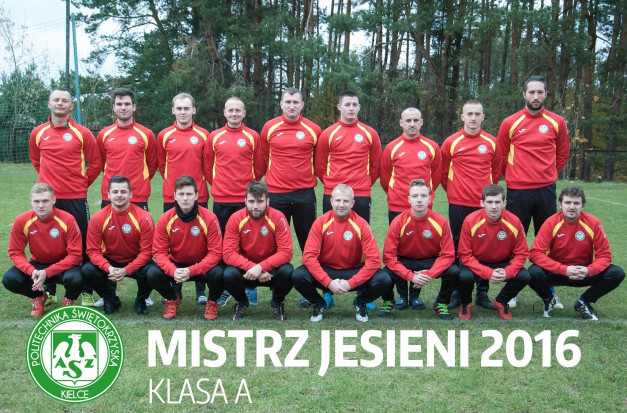 Drużyna piłkarska w czerwonych strojach z żółtymi elementami pozuje do zdjęcia.