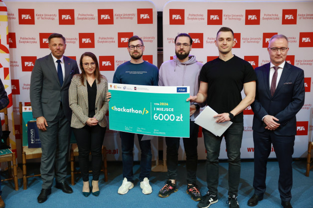 Grupa osób prezentuje czek na 6000 zł z okazji I miejsca na hackathonie.
