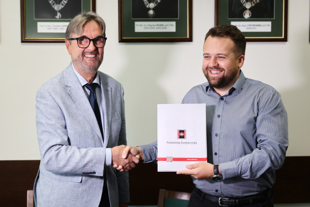 Dwóch mężczyzn, jeden w jasnej marynarce, drugi w koszuli, ściska sobie dłonie.