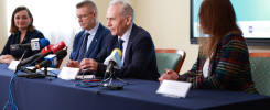 Konferencja prasowa z udziałem osób przy stole z mikrofonami. W tle ekran z napisem "AI i TY - Kielecki Informatyki".