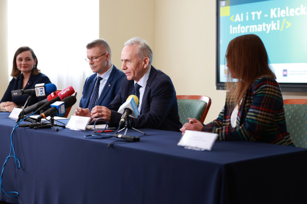 Konferencja prasowa z udziałem osób przy stole z mikrofonami. W tle ekran z napisem "AI i TY - Kielecki Informatyki".