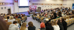 Wykład w sali z dużą grupą słuchaczy. Na ekranie prezentacja, prelegent przy mównicy.