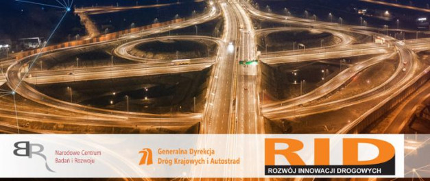 Nocny widok węzła autostradowego z oświetlonymi pasami ruchu. Loga NCBR, GDDKiA i RID.
