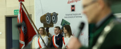 Flaga Polski i trzech studentów w szarfach. Tło: Politechnika Świętokrzyska. Kontekst: uroczystość.