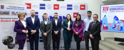 Grupa osób pozuje przed banerem Politechniki Świętokrzyskiej. Kluczowe obiekty: ludzie, baner, ekran.