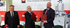 Trzech mężczyzn w garniturach ściska sobie dłonie, trzymając dokumenty. W tle logo Politechniki Świętokrzyskiej.