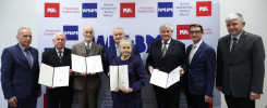 Siedem osób pozuje do zdjęcia z dyplomami. W tle baner Politechniki Świętokrzyskiej.