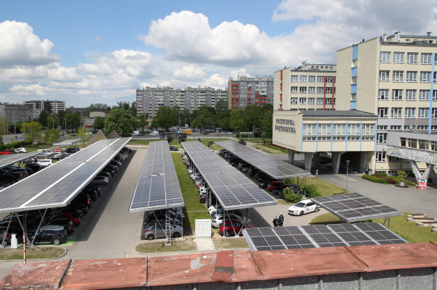 Parking z panelami słonecznymi przed budynkiem Politechniki Świętokrzyskiej.