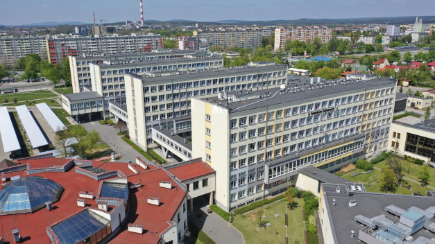 Budynki uniwersyteckie z czerwonym dachem i kopułą. W tle widać miasto.