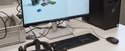 Monitor z symulacją fabryki, komputer, klawiatura, mysz, gogle VR.