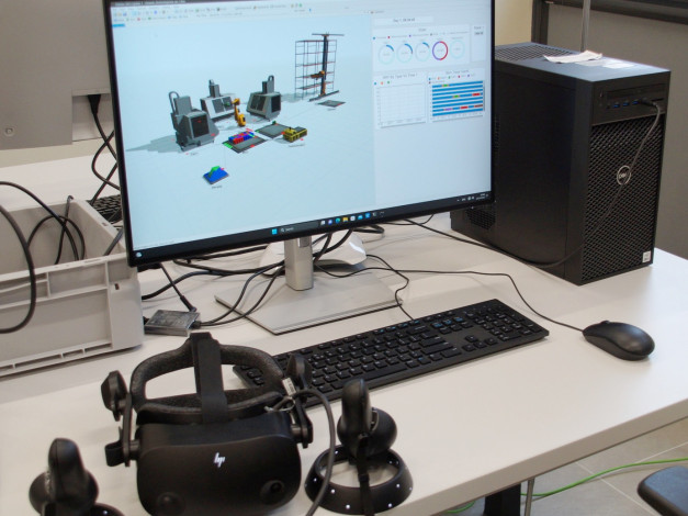 Monitor z symulacją fabryki, komputer, klawiatura, mysz, gogle VR.