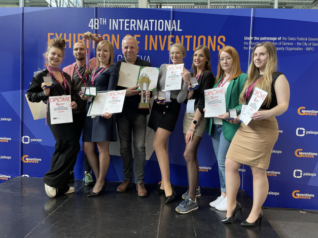 Grupa osób z dyplomami i medalami na 48. Międzynarodowej Wystawie Wynalazków w Genewie.