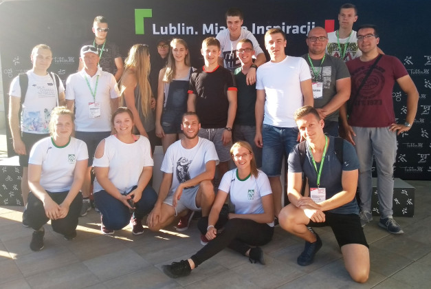 Grupa ludzi pozuje do zdjęcia na tle czarnego banera z napisem "Lublin. Miasto Inspiracji".