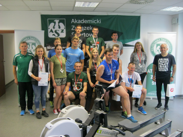 Grupa osób pozuje do zdjęcia z dyplomami i medalami. W tle baner "Akademicki Związek Sportowy".