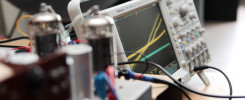 Oscyloskop Tektronix DPO 4104 z podłączonymi przewodami i elementami elektronicznymi.