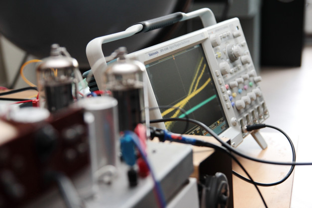 Oscyloskop Tektronix DPO 4104 z podłączonymi przewodami i elementami elektronicznymi.