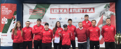 Grupa sportowców w czerwonych strojach pozuje na tle baneru "Akademickie Mistrzostwa Polski".