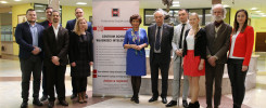 Grupa osób stoi przed banerem Centrum Ochrony Własności Intelektualnej Politechniki Świętokrzyskiej.