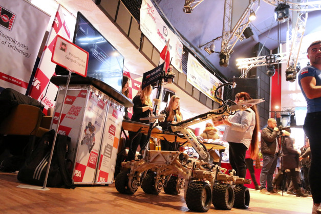 Na targach technologicznych prezentowany jest robot mobilny. Widać banery Politechniki Świętokrzyskiej.