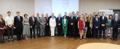 Grupa osób pozuje do zdjęcia w sali konferencyjnej. W tle ekran z napisem "Politechnika Świętokrzyska".