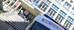 Samochód służbowy z napisem "SŁUŻBA KREW" przed budynkiem uczelni.