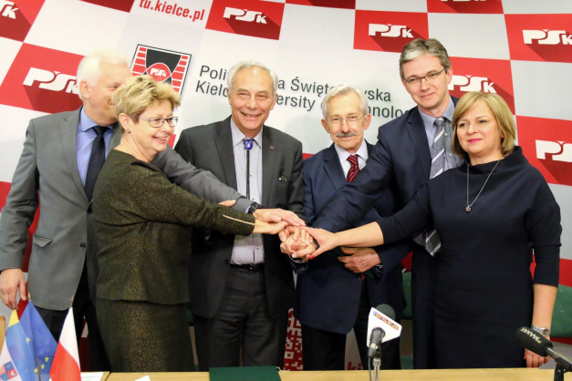 Sześć osób w strojach formalnych łączy dłonie. Kontekst: wydarzenie związane z Politechniką Świętokrzyską.