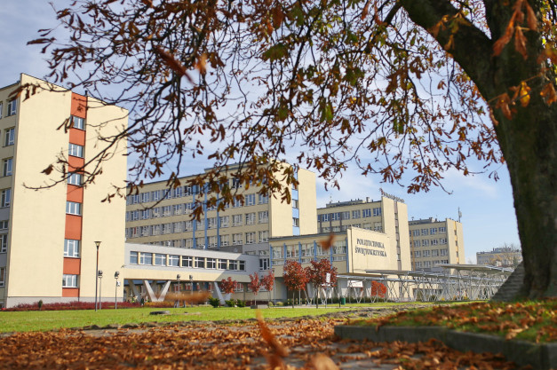 Budynki Politechniki Świętokrzyskiej w Kielcach. Jesień, liście na drzewach i trawie.