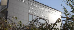 Budynek Politechniki Świętokrzyskiej z napisem "Biblioteka Główna". W kadrze gałęzie drzew.