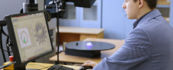 Mężczyzna pracuje przy komputerze z programem CAD. Na biurku monitor, klawiatura, mysz i skaner 3D.