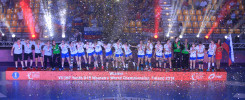 Drużyna piłki ręcznej świętuje zwycięstwo na podium, obsypana konfetti.