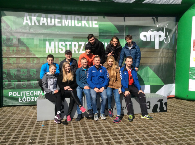Grupa osób na podium przed banerem "Akademickie Mistrzostwa Politechniki Łódzkiej".
