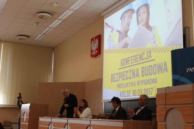 Konferencja "Bezpieczna Budowa" w Kielcach 30.03.2017. Na ekranie projektora widoczni są ludzie w kaskach.