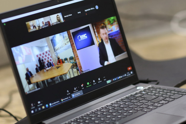 Laptop z widokiem na wideokonferencję Zoom.
