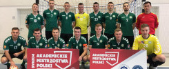 Drużyna piłki nożnej w zielonych strojach pozuje do zdjęcia.