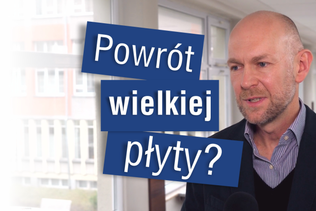 Mężczyzna w garniturze i koszuli. Na niebieskich tablicach napis: "Powrót wielkiej płyty?". Kontekst: wywiad.