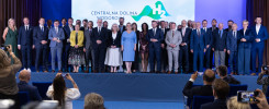 Grupa osób w strojach formalnych stoi na scenie przed ekranem z logo "Centralna Dolina Wodorowa H2".