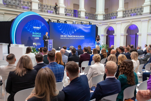 Mężczyzna przemawia na scenie przed ekranem z logo NCBR. Kontekst: wydarzenie związane z programem LIDER.