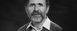 Portret mężczyzny w swetrze i koszuli. Kluczowe obiekty: twarz, broda, sweter, koszula. Kontekst: portret.