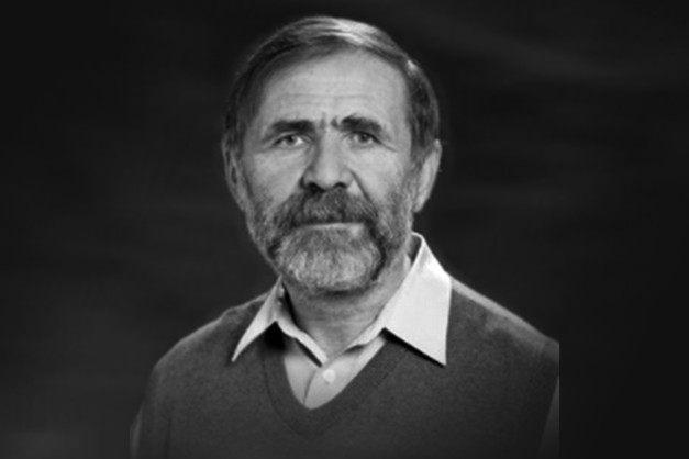 Portret mężczyzny w swetrze i koszuli. Kluczowe obiekty: twarz, broda, sweter, koszula. Kontekst: portret.