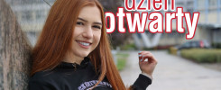 Uśmiechnięta rudowłosa dziewczyna w bluzie z kapturem z logo uczelni. Napis "Dzień otwarty".