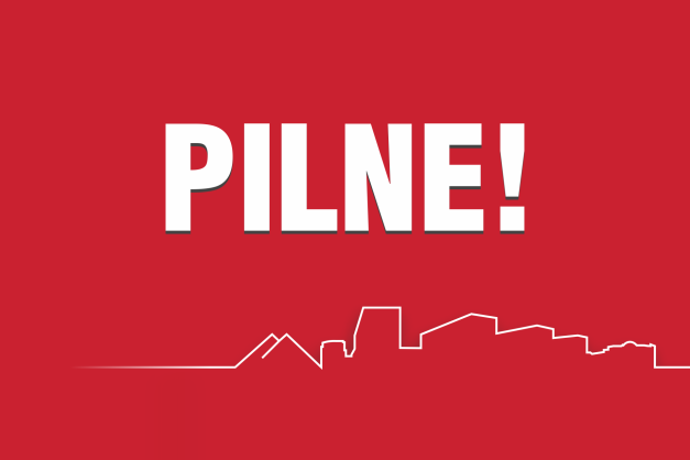 Biały napis "PILNE!" na czerwonym tle. Poniżej biały zarys panoramy miasta.