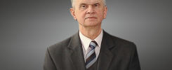 Portret starszego mężczyzny w garniturze i krawacie.