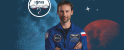 Astronauta w niebieskim kombinezonie z naszywkami ESA i polską flagą, na tle księżyca i gwiazd.