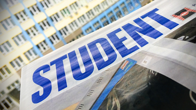 Napis "STUDENT" na białym tle. W tle budynek z oknami.
